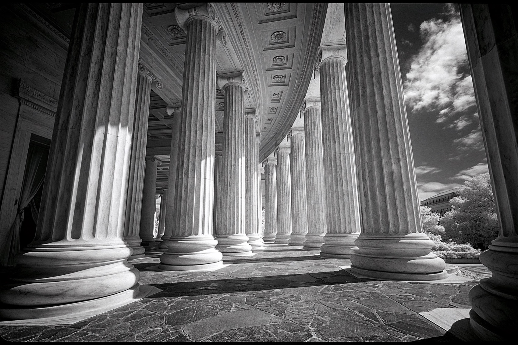 A long colonnade of identical marble columns receding into shadow